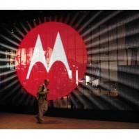 A man walks by a video display at the Motorola booth on the second day of the Consumer Electronics Show (CES) in Las Vegas